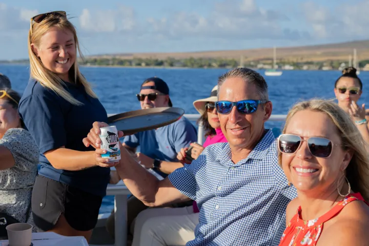 a group of people posing for a picture next to a body of water