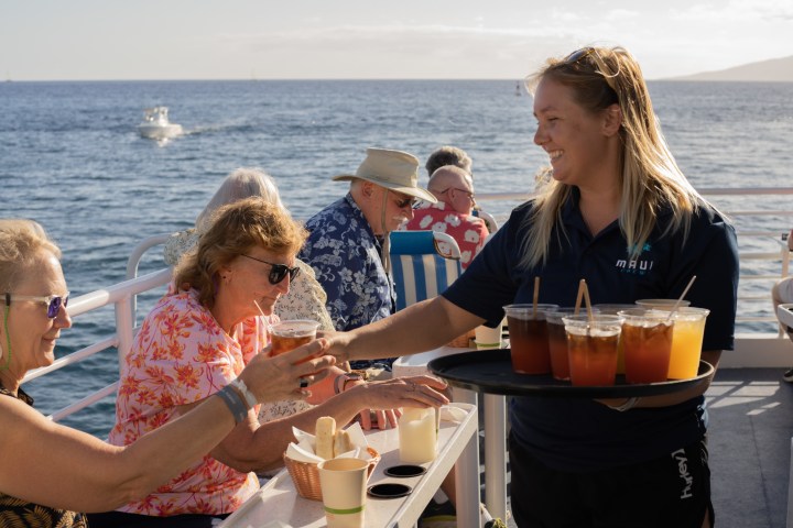a couple of people are drinking from the water