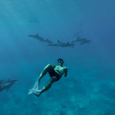 a man flying through the air while riding a wave in the ocean