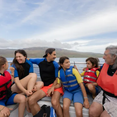 a group of people sitting next to a body of water