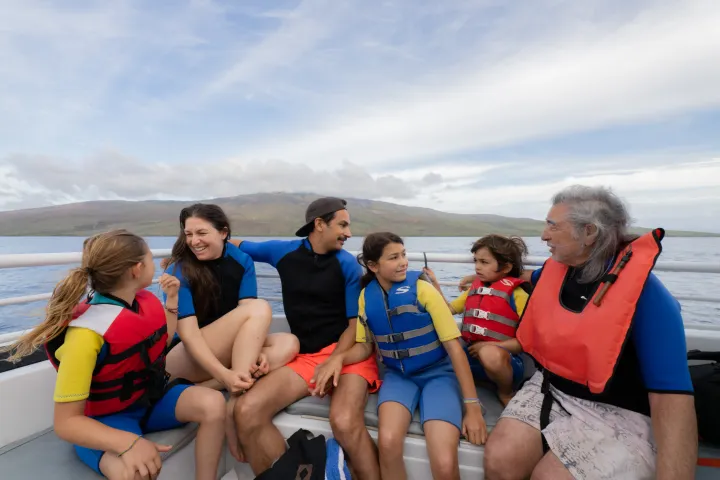 a group of people sitting next to a body of water