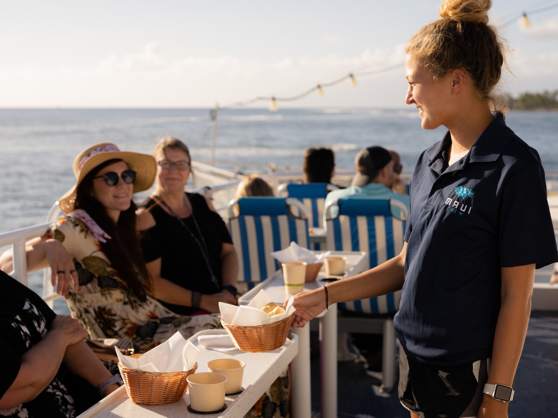 a group of people sitting at a table with food and water